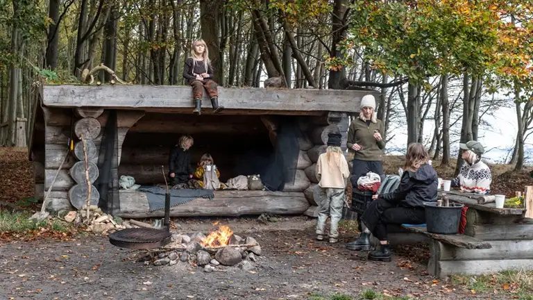 Familie på shelterplads med bål