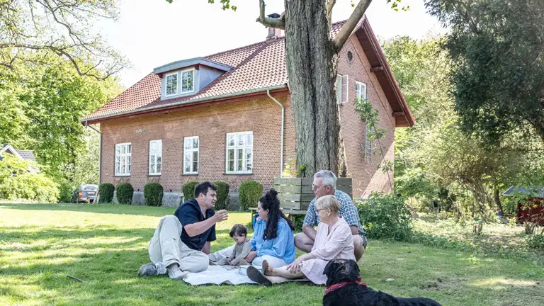 Familie i Nyråd med villa i baggrunden